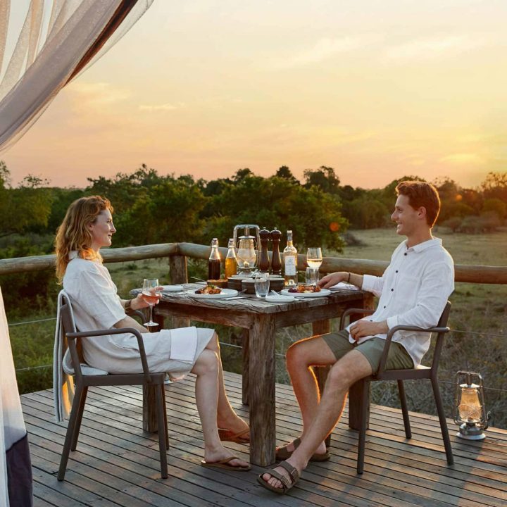 A couple enjoying a sundowner on the deck.