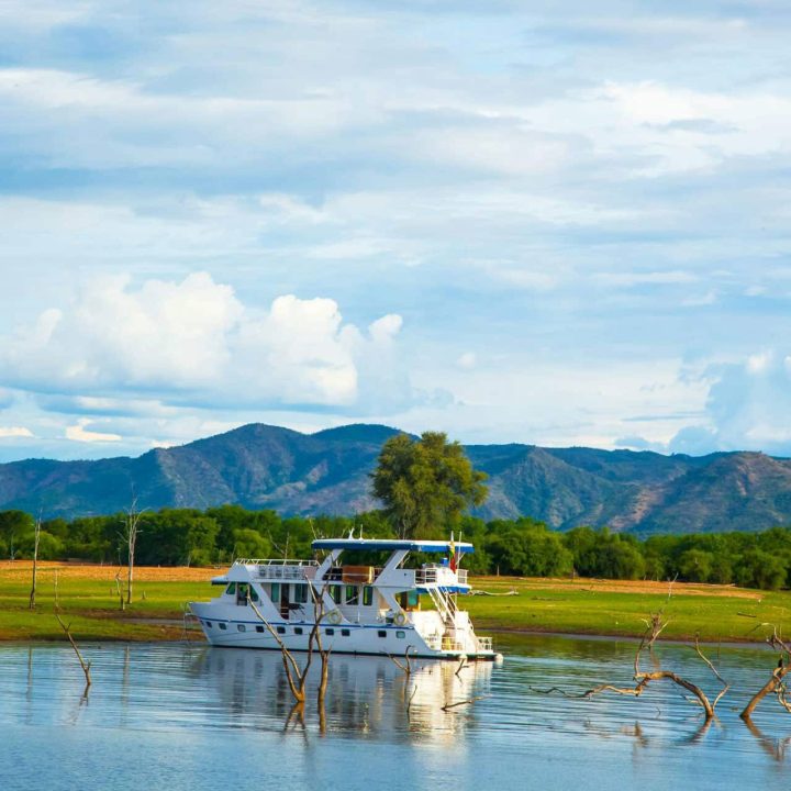 A houseboat moored in sight of dramatic scenery.