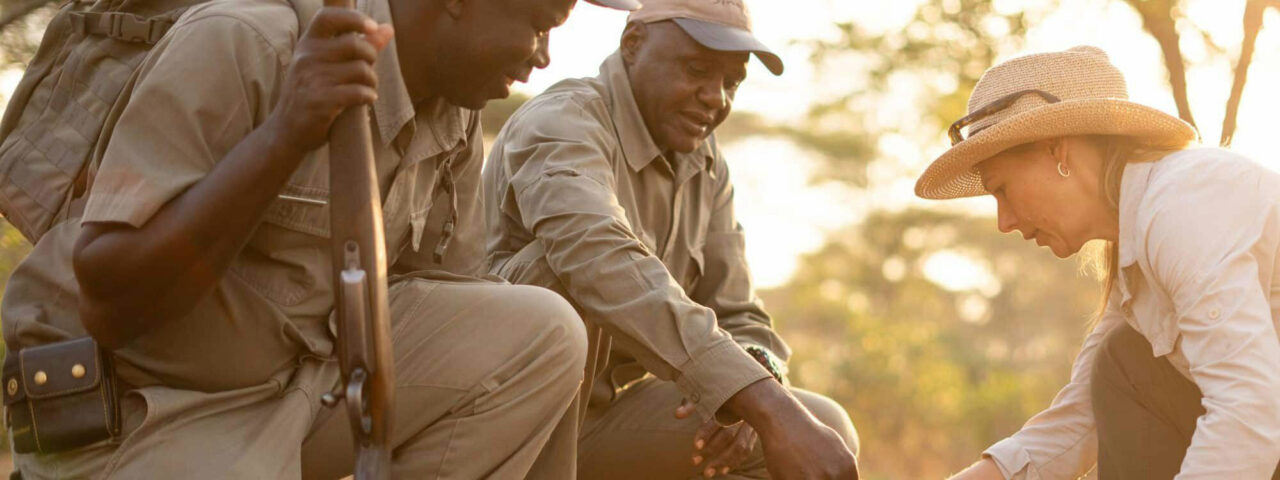 Two private guides helping a tourist on safari.