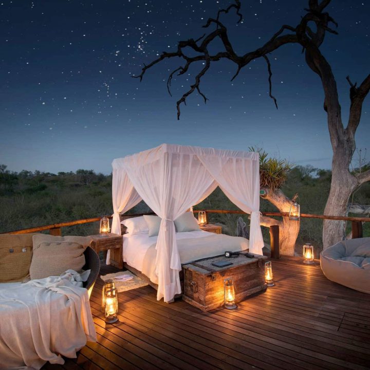 A four poster bed under an African sky.