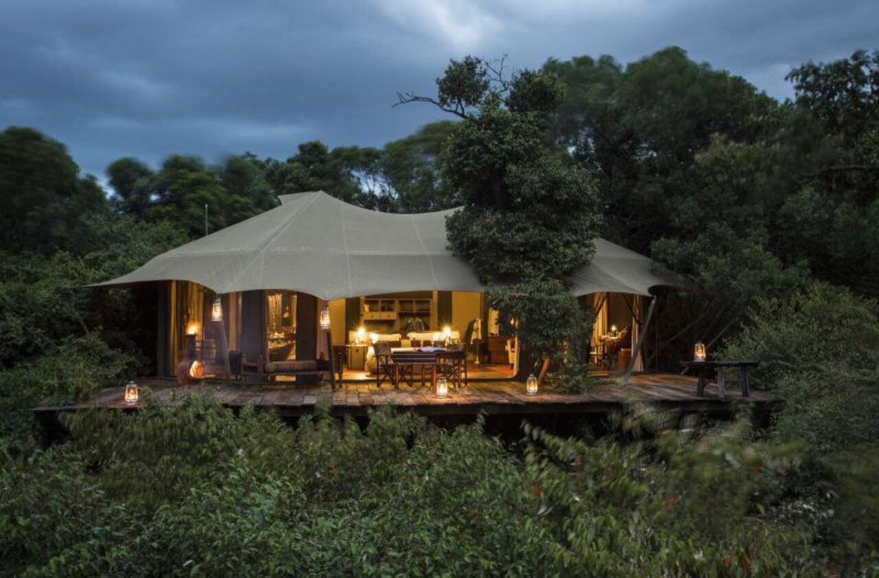 A canvas-walled guest tent overlooks the plains, Mara Plains Camp, Maasai Mara, Kenya, a moment from a luxury safari holiday.