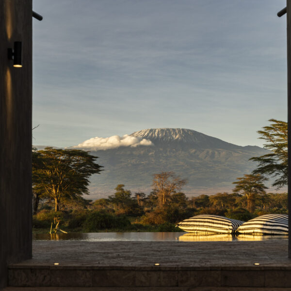 Mount Kilimanjaro seen at dusk across the landscape from a terrace at Angama Amboseli, Kenya.