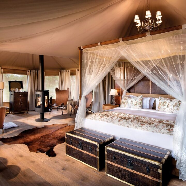 A canopied bed and copper soaking tub furnish this luxury safari tented suite, One Nature Nyaruswiga, Tanzania.