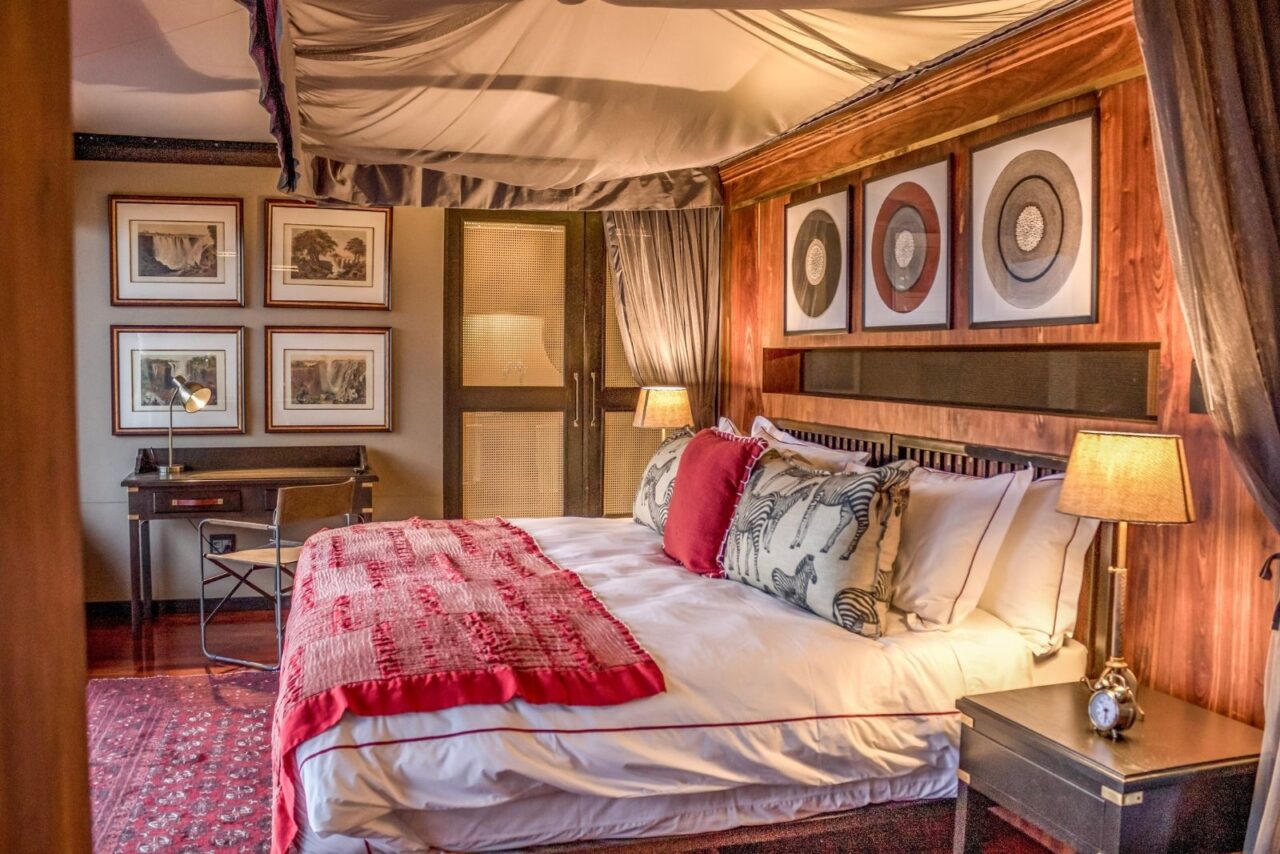 A cosy, colourful tented bedroom at this luxury safari camp is warmly lit, Garonga, South Africa.